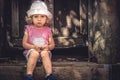 Sad lonely child girl upset look sitting lonely on door steps old house copy space