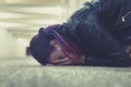 Sad and lonely girl crying with a hand covering her face. Young woman sitting on the floor in the underpass and crying heavily fro Royalty Free Stock Photo