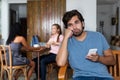 Lonely hipster man waiting for text message of girlfriend