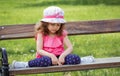 Sad lonely little girl sitting on bench