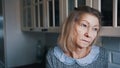 Sad lonely old gray haired woman looking through the window. Vulnerable person in quarantine Royalty Free Stock Photo