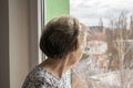 Sad lonely old woman look next to window allone depressed abandoned