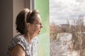 Sad lonely old woman look next to  window allone depressed abandoned Royalty Free Stock Photo