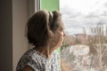 Sad lonely old woman look next to  window allone depressed abandoned Royalty Free Stock Photo