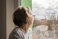 Sad lonely old woman look next to  window allone depressed abandoned Royalty Free Stock Photo