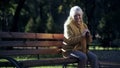 Sad lonely old woman sitting on bench in park, abandoned elderly people alone Royalty Free Stock Photo