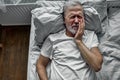 sad lonely senior lying on bed in a hospital, hospitalization concept