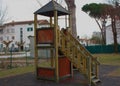 A sad and lonely slide, built in wood, old-fashioned. the playground is isolated, empty, without children. the winter day is sad