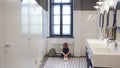 Sad and lonely teen girl sit on restroom floor alone Royalty Free Stock Photo