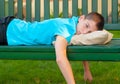 Sad lonely teenage boy lying on the bench Royalty Free Stock Photo