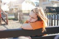 Sad lonely teenage girl sitting on bench in the playground Royalty Free Stock Photo