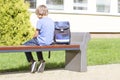 Sad, lonely, unhappy, disappointed boy sitting alone near school. Backpack. Casual clothes. Outdoor