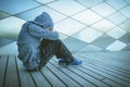 Sad, lonely, unhappy, disappointed child sitting alone on the ground outdoors Royalty Free Stock Photo