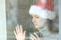 Sad woman looking through a window in christmas Royalty Free Stock Photo