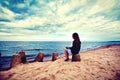 Sad, lonely woman sitting on the beach. Royalty Free Stock Photo