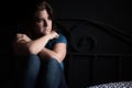 Sad and lonely woman sitting on her bed Royalty Free Stock Photo