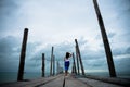 Sad and lonely woman stand alone on a the wooden bridge