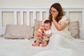 Sad lonely woman with a toddler baby is lying alone in an empty bed. M Royalty Free Stock Photo