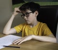 Sad looking boy doing homework during quarantine time Royalty Free Stock Photo
