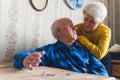 Sad, lost and worried caucasian senior couple counting their last coins while sitting at the table. Financial Crisis Royalty Free Stock Photo