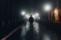Sad man alone walking along the alley in night foggy park. Back view Royalty Free Stock Photo