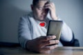 Sad man being dumped on phone by her woman, broken heart concept, crying in dark Royalty Free Stock Photo