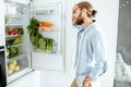 Sad man near the refrigerator full of vegetables at home Royalty Free Stock Photo