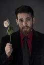 Sad Man in Formal Wear Holding Withered Rose