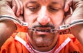 Sad Man with Handcuffs in Prison Royalty Free Stock Photo