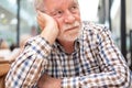 Sad man - handsome bearded elderly man sitting thoughtfully holding his head with hand, concept of unhappiness, stress depression