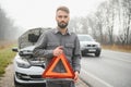 Sad man near broken car searching help in field