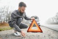 Sad man near broken car searching help in field