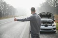 Sad man near broken car searching help in field