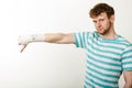 Sad man showing thumb down by bandaged hand. Royalty Free Stock Photo