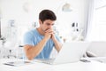 Sad man sitting at desk at home with a laptop. Freelance and selfemployment concept Royalty Free Stock Photo