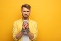 Sad man with tied hands with metal chain holding smartphone