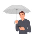 Sad man with umbrella stands in rain and reads SMS in mobile phone from girlfriend who refused to come on date. Concept of autumn Royalty Free Stock Photo