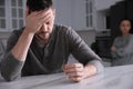 Sad man with wedding ring in kitchen. Couple on verge of divorce