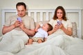 Sad man and woman with toddler baby looking in a mobile phone. Fath Royalty Free Stock Photo