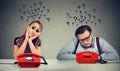 Sad man and woman waiting for a phone call from each other have many questions Royalty Free Stock Photo