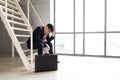 Sad Marketing businessman sitting on staircase inside the office after losing job. Young unemployed man in suit covering face with Royalty Free Stock Photo