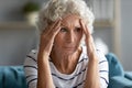 Sad mature woman touching temples close up, feeling unwell