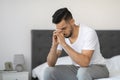 Sad Middle Eastern Man Sitting on Bed Appears Deep in Thought at Home Royalty Free Stock Photo
