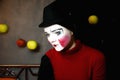 Sad mime in a hat with apples