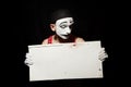 Sad mime holding white paper dirty sheet in hands