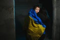 Sad mother hugging her son, both wearing Ukrainian national colors on black background