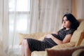 Worried Pregnant Woman Sitting on a Couch