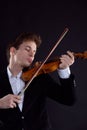 Sad music, the concept of bad luck. The young violinist is elegantly dressed, shaken, and plays the violin.