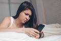 Sad news. Upset young woman with mobile phone reads the message Royalty Free Stock Photo