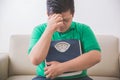 Sad obese man holding a weight scale, thinking about his weight Royalty Free Stock Photo